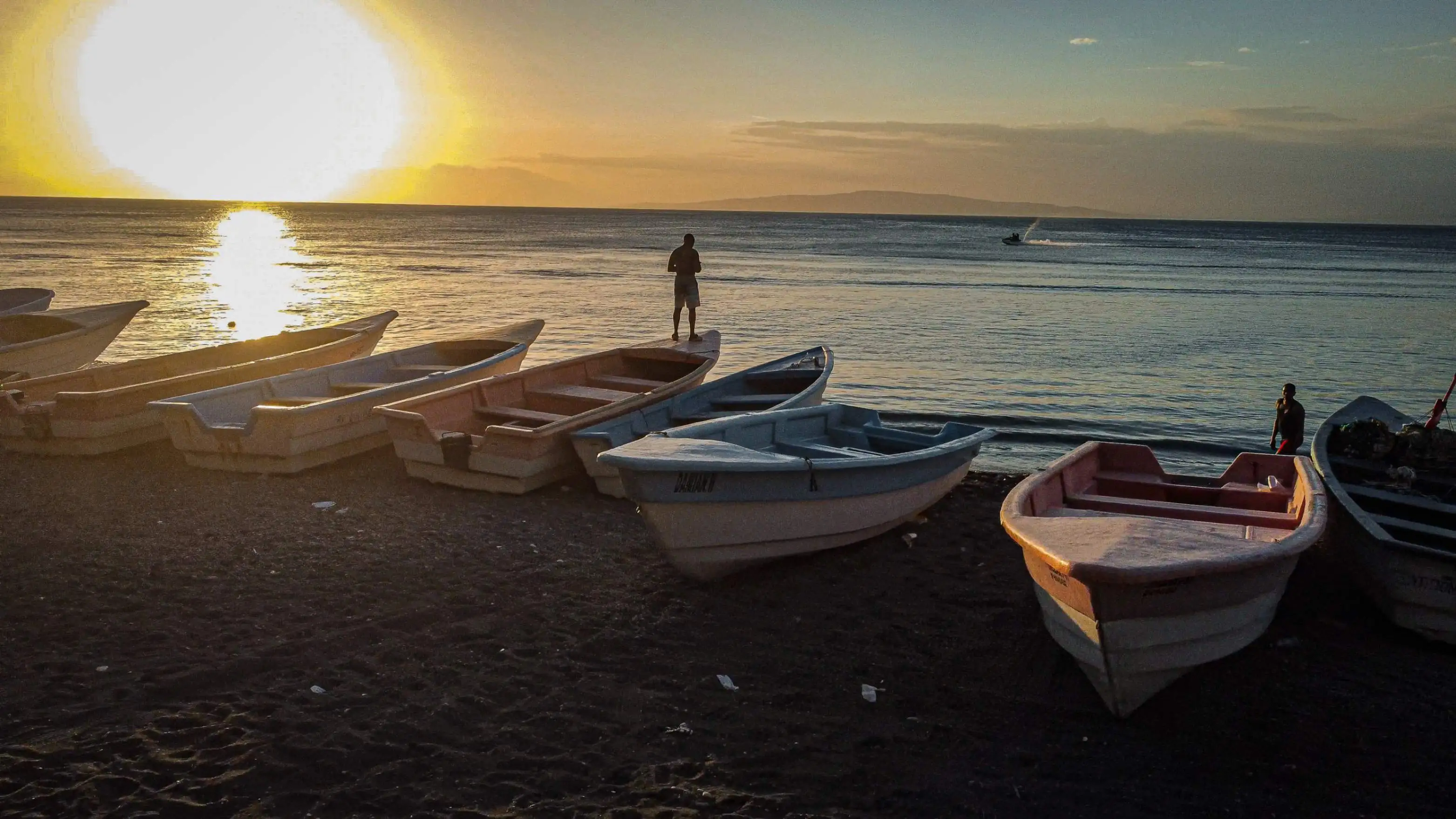 Atardecer en Playa Palmar de Ocoa con botes al fondo y mar tranquilo