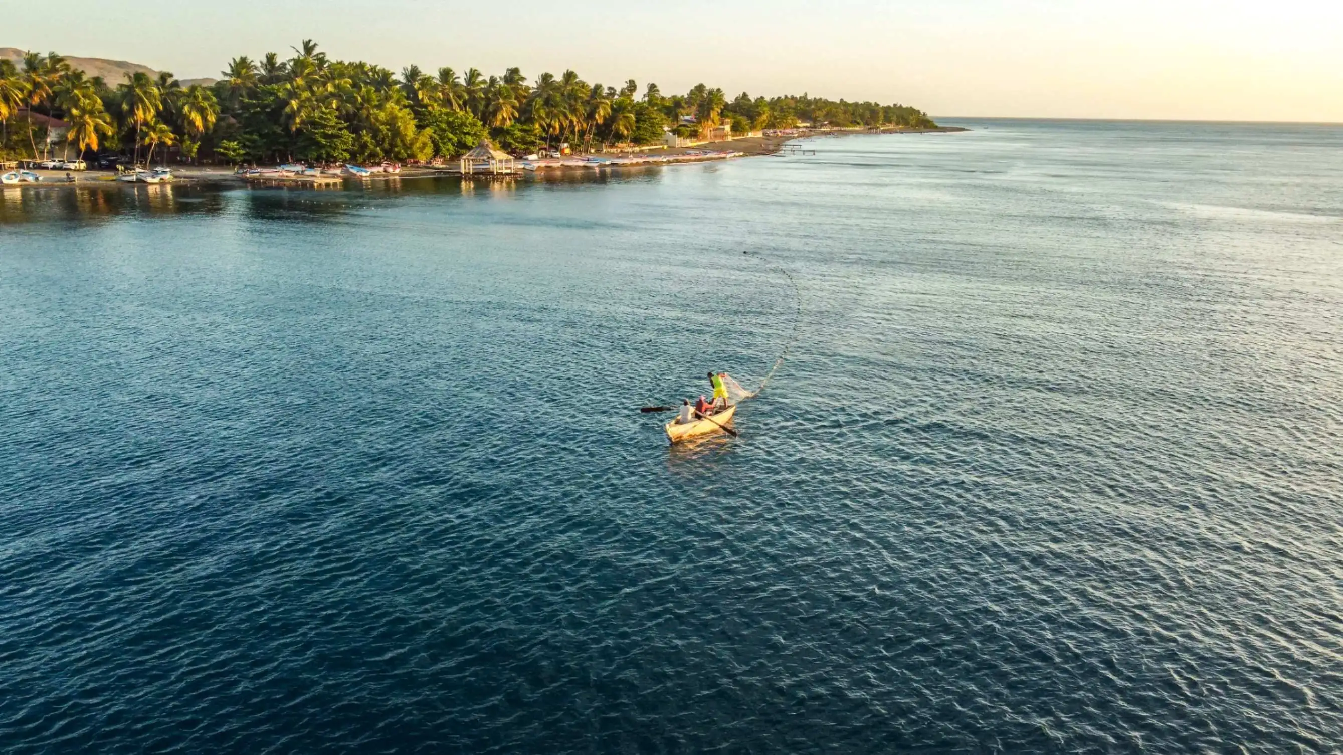 Pescadores en Playa Palmar de Ocoa con montañas al fondo y mar en calma